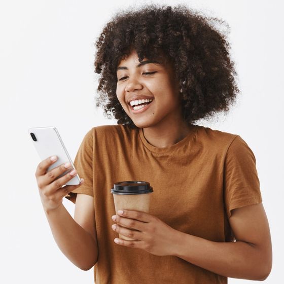 Una joven sonríe mirando su celular